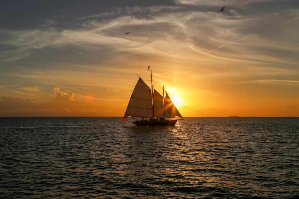 a sailboat at sunset which is showing one of the best Kauai Tours