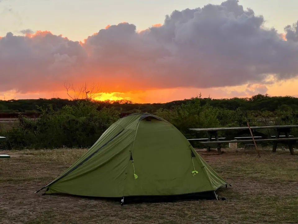 Sunrise at Salt Pond Beach Park with a green tent in view which is one of the best places to go camping in Kauai