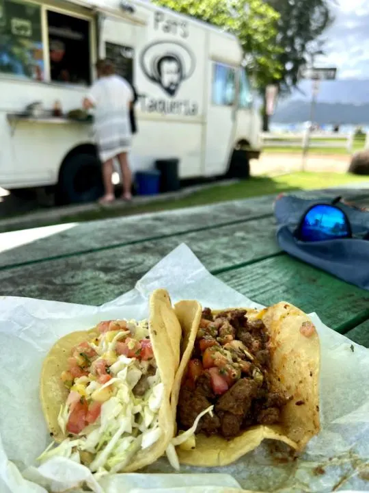 a carne asada and fish taco in front of Pat's Taqueria at Black Pot Beach in Hanalei which is Pat's Taqueria at Black Pot Beach in Hanalei