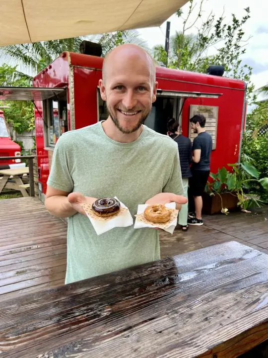a guys holding Taro Donuts in front of Kauai's best restaurant for doughnuts, Holey Grail Donuts