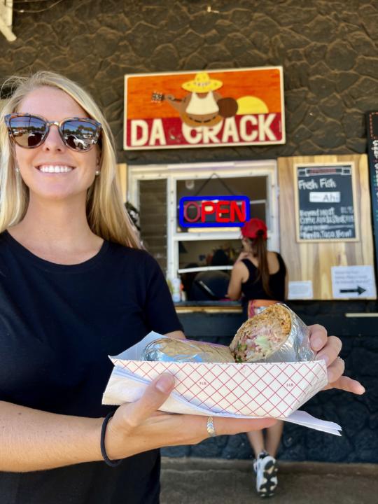 a chicken burrito being held in front the most affordable best restaurants in Kauai, Da Crack 