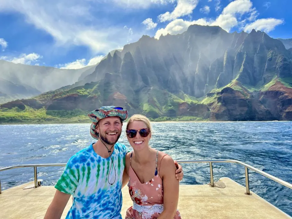 Couple posing in from of Napali Coast Kalalau Beach from Boat