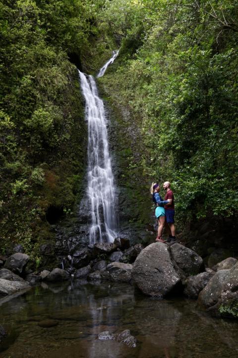 Two Roaming Souls cutely posing in front of Lulumahu Falls, one of the best hikes in Oahu