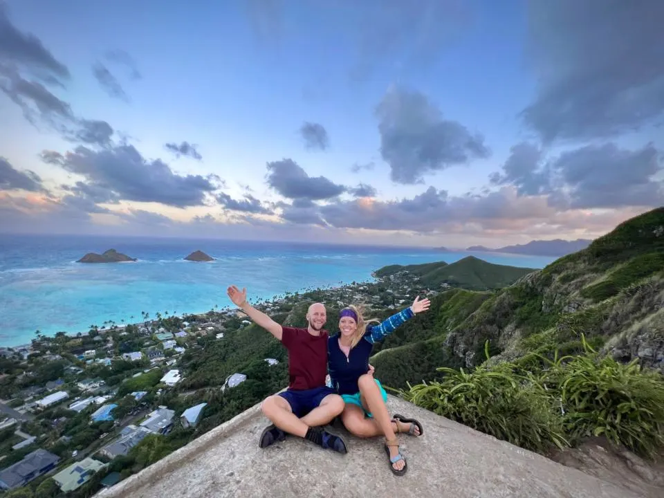 wide angle view of a couple at the top of Lanikai Pillboxes, one of the best hikes in Oahu