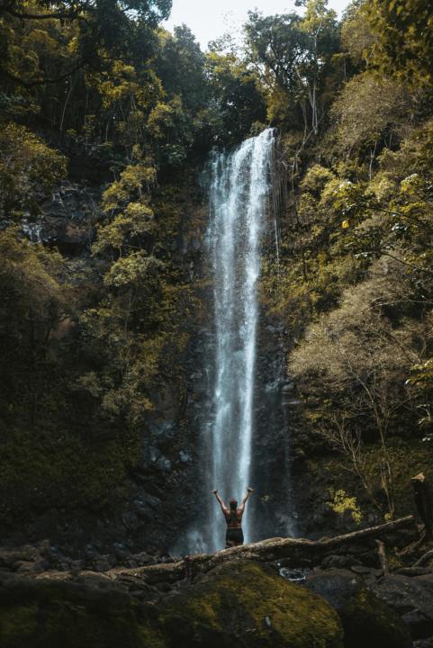 a girl in front of Secret Falls in kauai which is one of the best hikes in Kauai