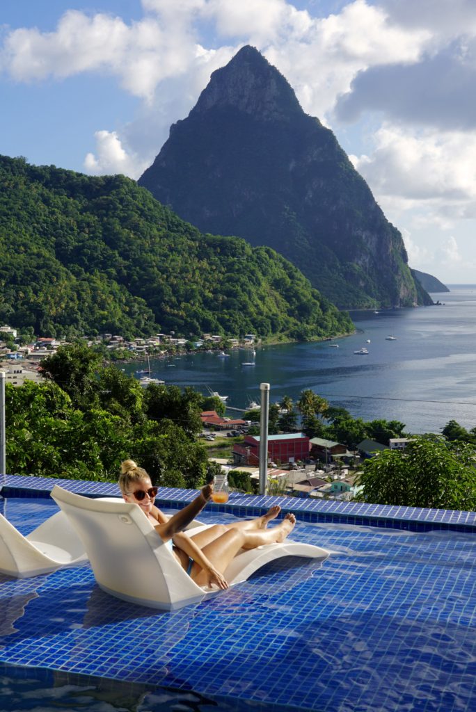 Emily cheersing her cocktail from the pool at Green Fig Resort, one of the best resorts in St. Lucia that offers epic views of Petit Piton