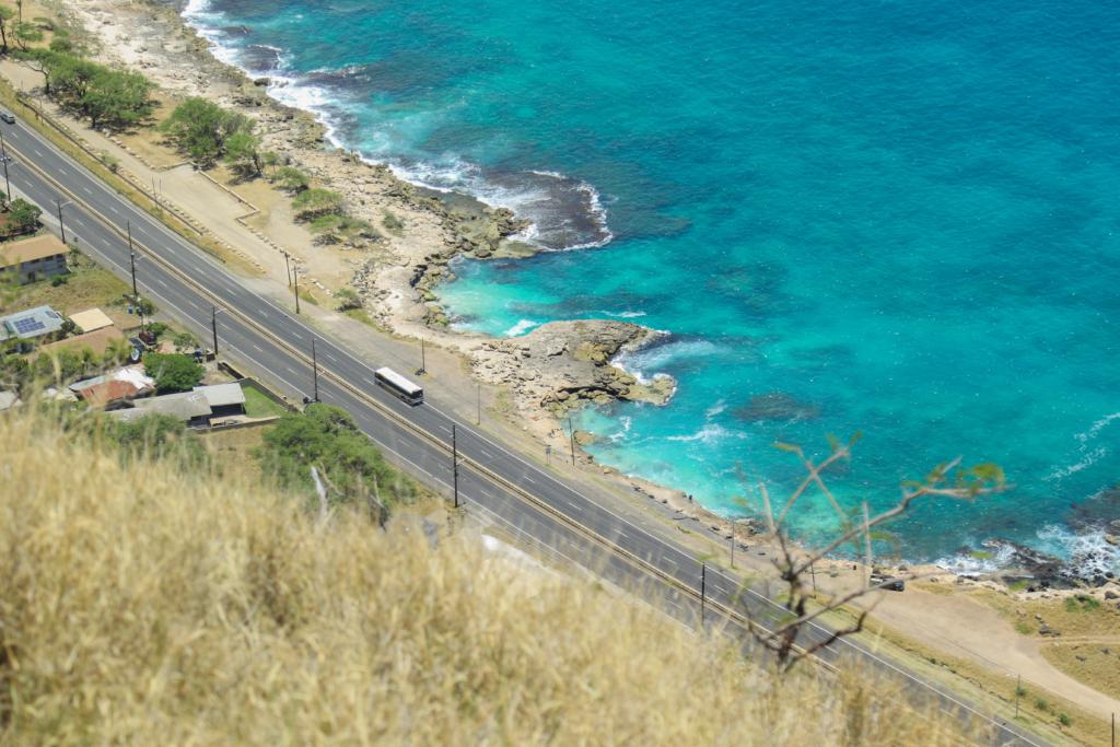 A bus driving along the coast in Oahu.