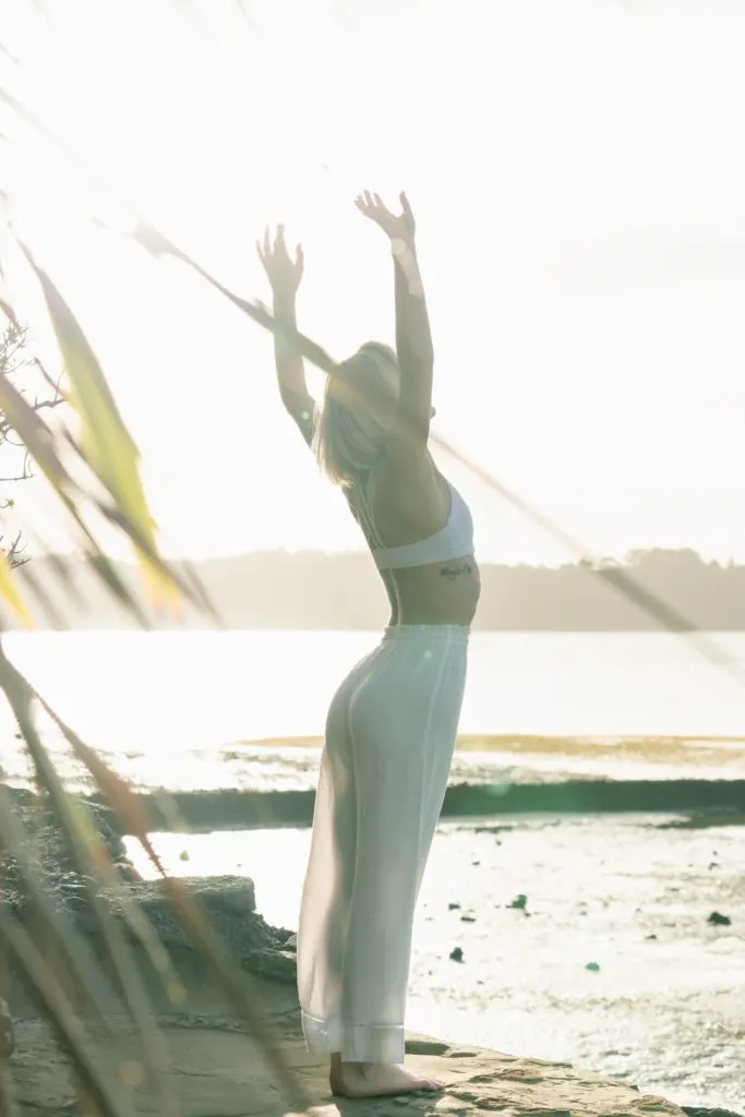 a girl doing yoga by the beach which is representing Sol Sanctum Hotel and Wellness Studio, one of the affordable St. Lucia Resorts & Hotels