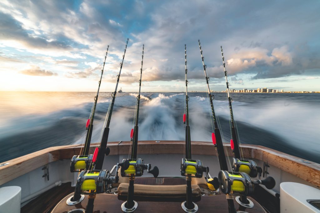4 rods hanging off a fishing boat, showing that a fishing charter is one of the best Kauai Tours