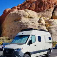 Mercedes Sprinter Campervan against sandstone background.