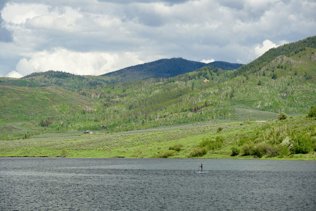 a guy paddle boarding on Stagecoach Reservoir in Steamboat Spring, CO