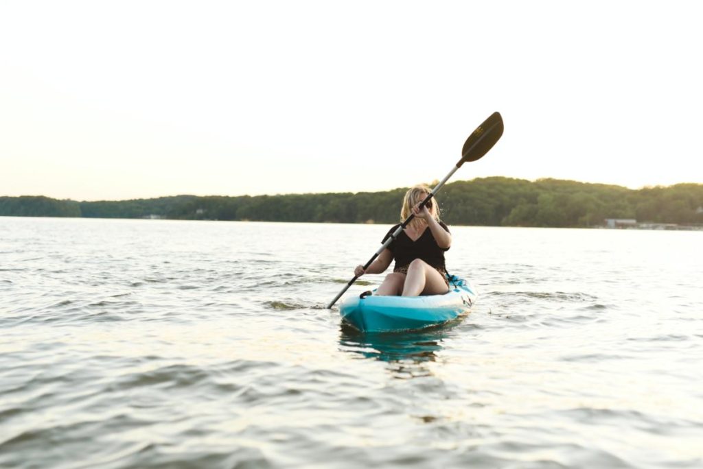 a girl in a lightweight kayak on a lake