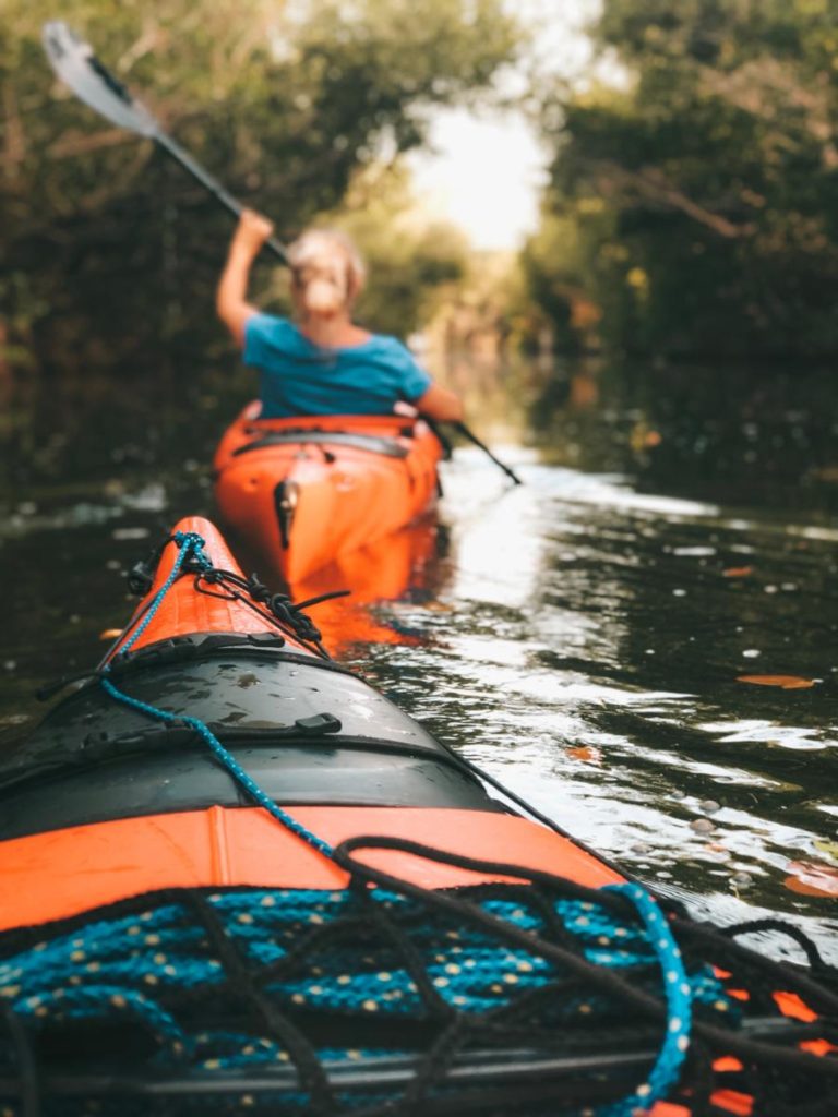 a lightweight kayak paddling through a canal