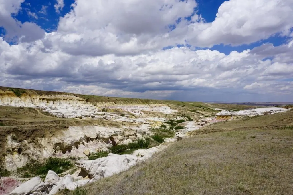 The grassy prairie, gives way to the Paint Mines badlands.