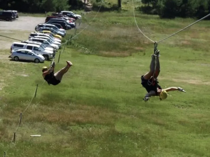 two people racing on the ziplines at the ends of the Northwoods Zip Line Adventure Tours