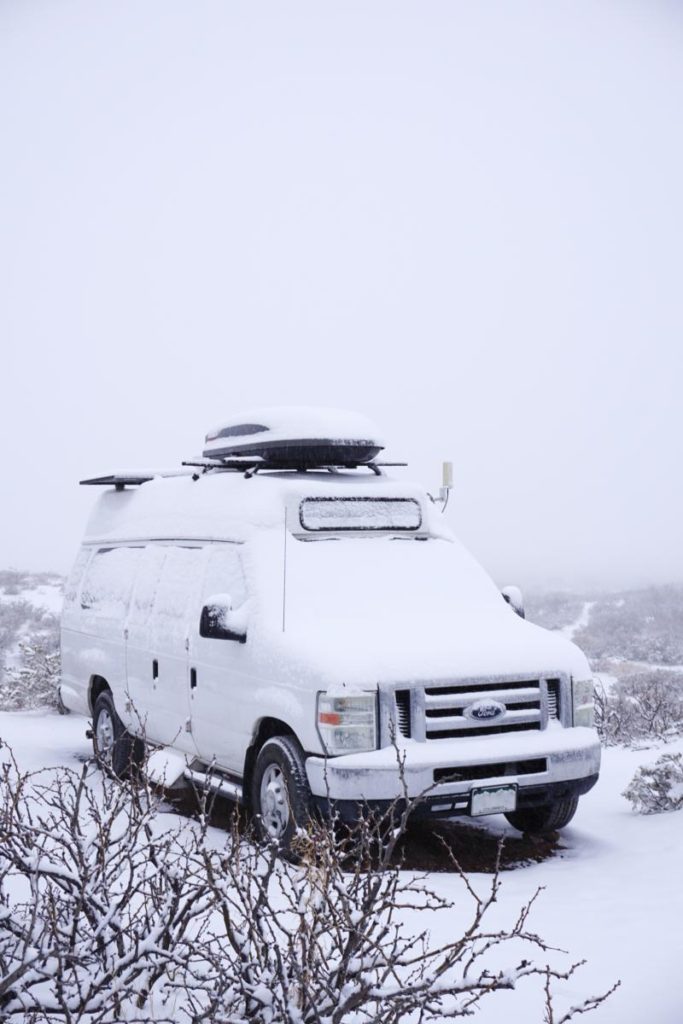 A Ford campervan covered in fresh snow.
