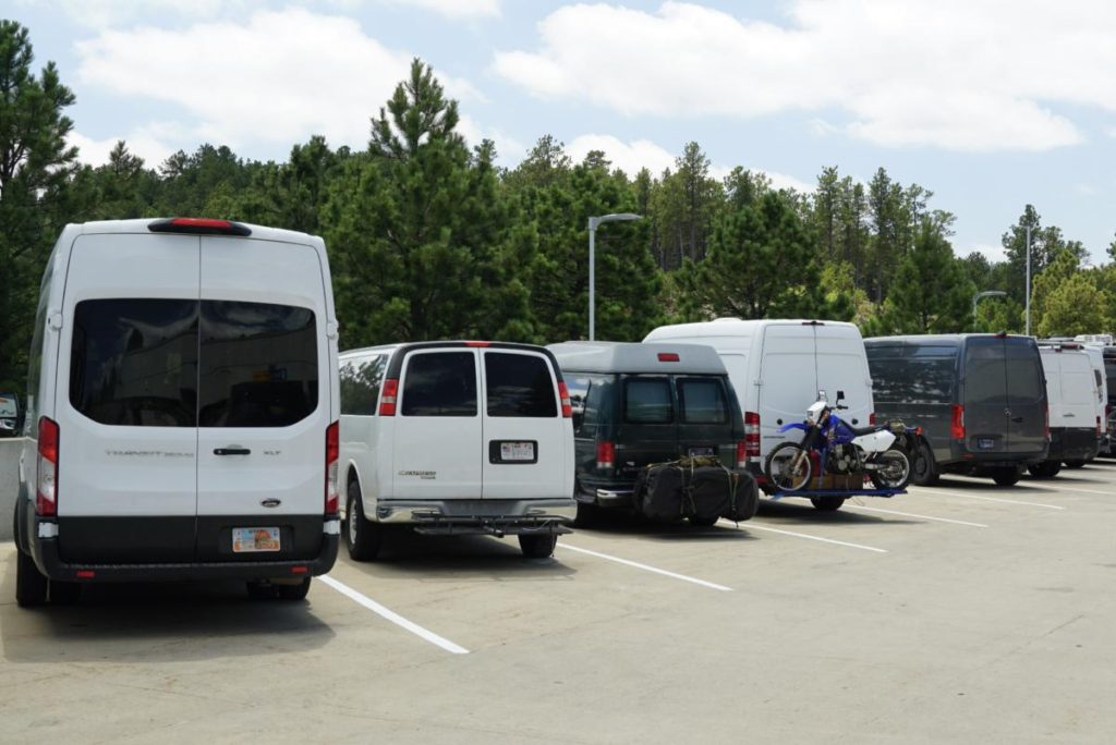 A lineup of campervans in a parking lot.