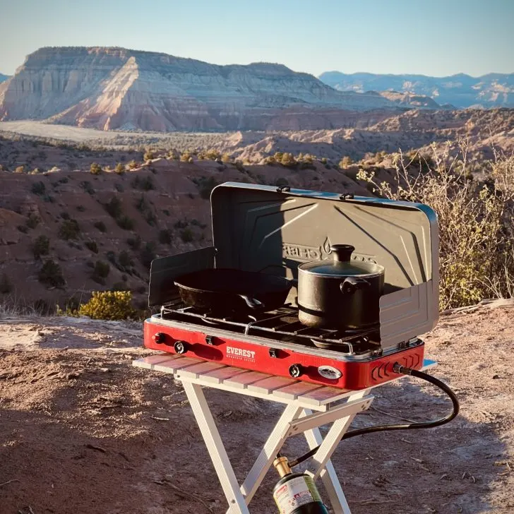 the camp chef everest in front of a beautiful outdoor mountain desert setting, showing that it is one of the best camp stoves