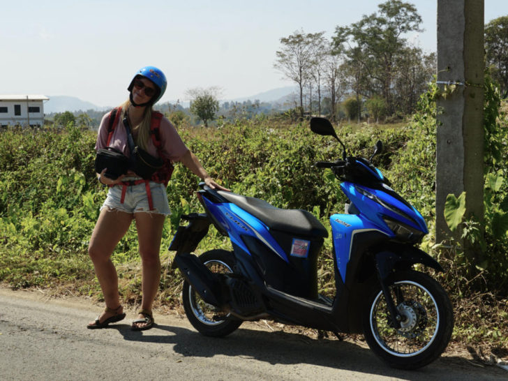 Emily renting a motorbike in a rural area of Thailand