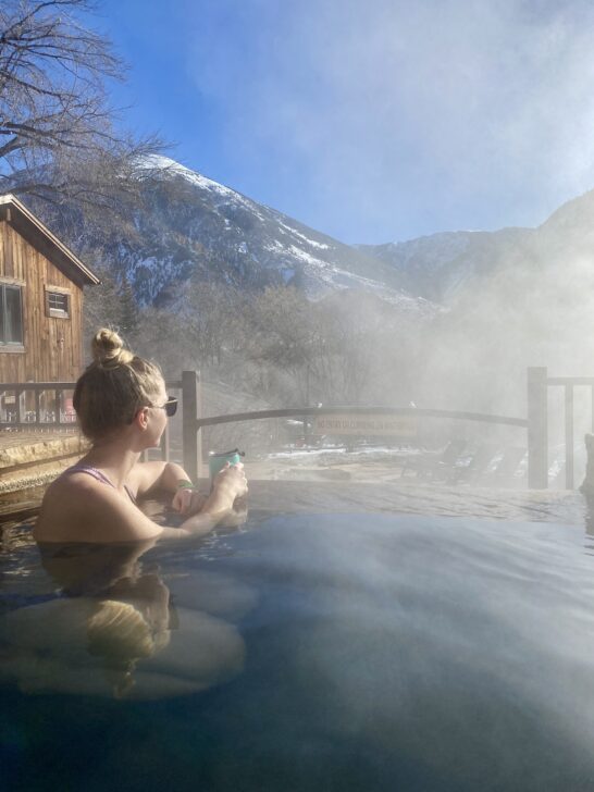 emily sitting in a hot spring in colorado, which can also double as one of the best places to shower on the road