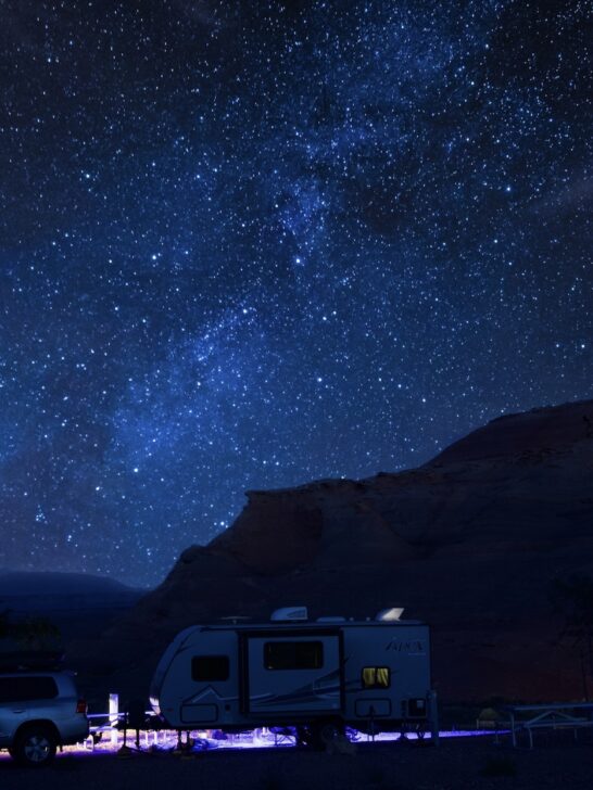 A camper trailer under a starry sky.