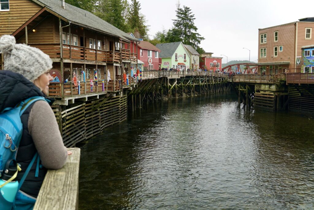 Emily posing over the railing along Creek Street, a popular free activity when visiting Ketchikan, AK on the Norwegian Jewel Alaska Cruise