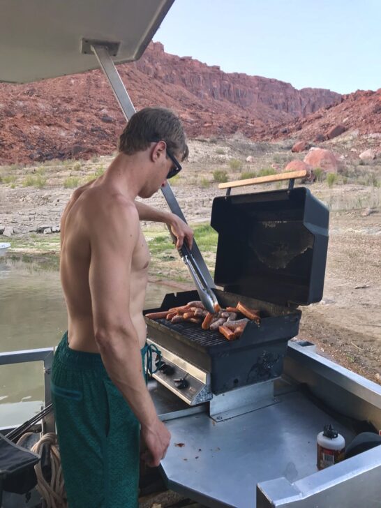 Grilling sausages and hot dogs on the houseboat grill.