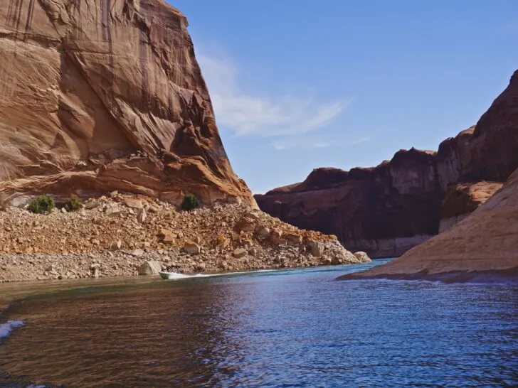 A powerboat navigating the tall red rock canyons of Lake Powell.