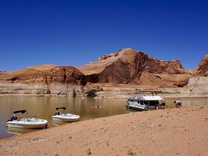 A rental houseboat anchored to a beach on Lake Powell.