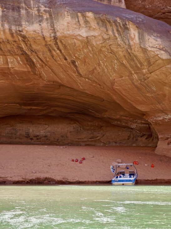 A Powerboat beached under a massive cliff at Lake Powell.