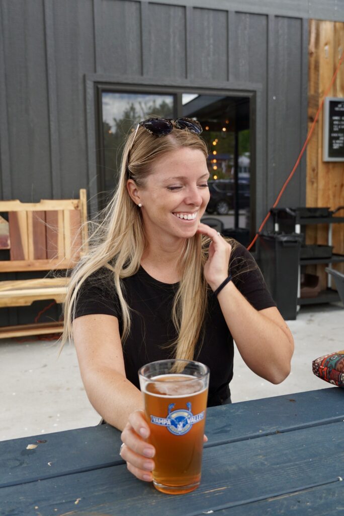 Emily enjoying a beer on the patio in her short-sleeve Unbound Merino T-Shirt