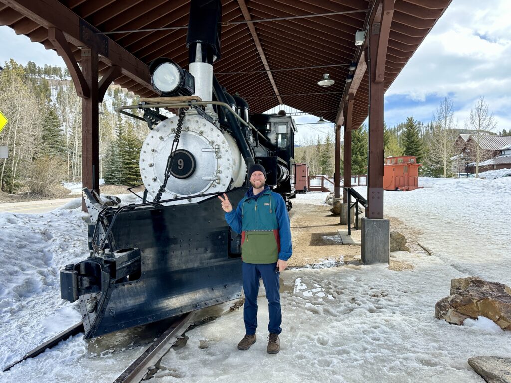 Jake standing in front of The Old Train Engine No. 9 in Breckenridge, CO