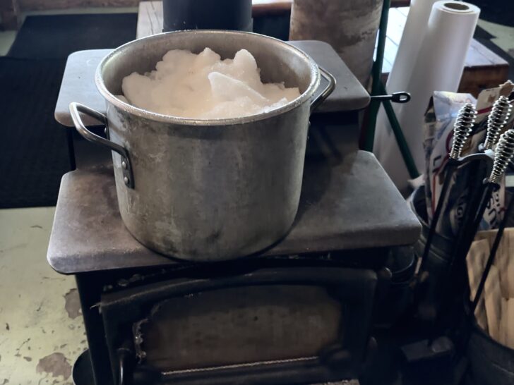Snow melting in a pot on top of the woodstove.