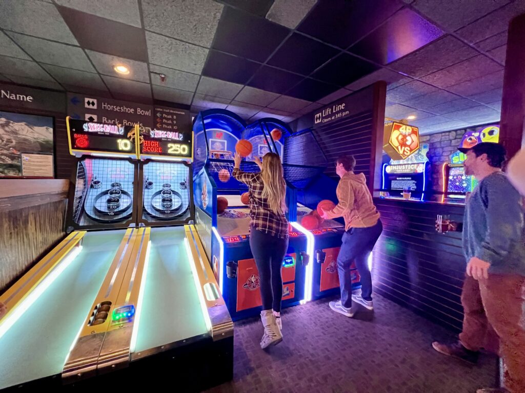 Skee Ball and 2 people playing basketball at the Arcade at Downstairs at Eric's in Breckenridge, CO