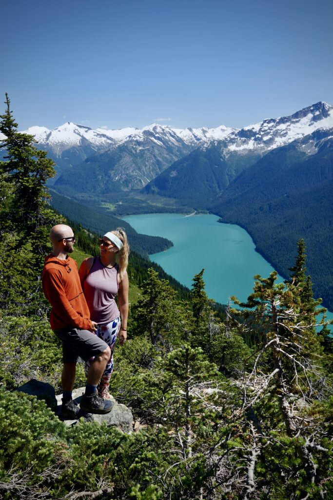 Jake and Emily posing with a look into eachothers eye with Cheakamus Lake in the background along High Note Trail