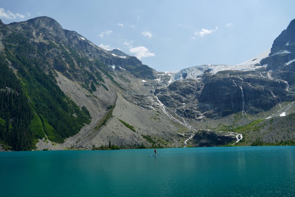 Emily paddle boarding with Joffre Lakes gracier in the background