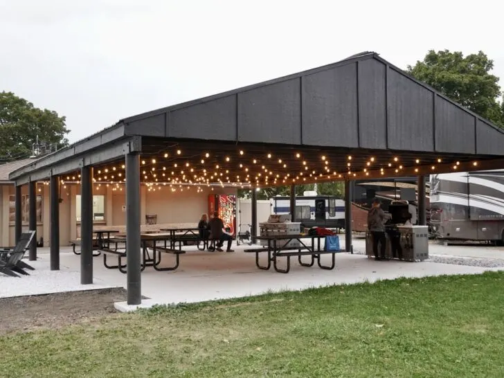 newly renovated outdoor pavillion at the Spokane KOA Journey, with string lights, picnic tables, etc