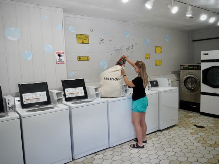 Emily pulling clothes out of the laundry bag to do laundry at the communal laundry facilities at Spokane KOA