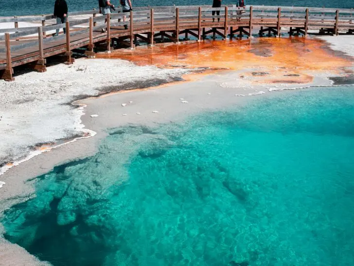 the depths and aqua colors of Abyss Pool and the boardwalk with Yellowstone Lake in the distance via the west thumb geyser trail