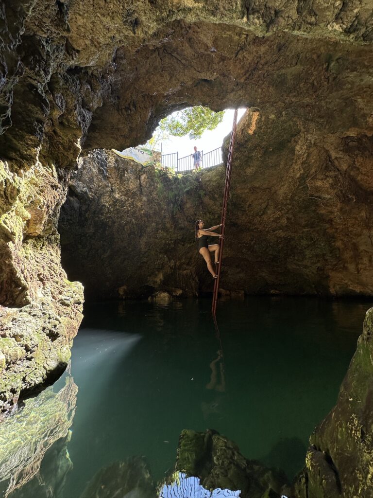 Emily climbing the ladder up inside the Blue Hole Mineral Spring