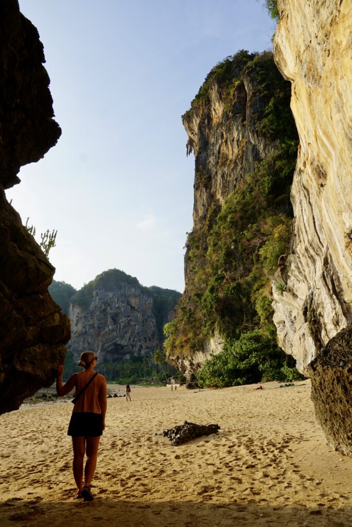 emily looking up at the rock wall from the entrance of Tonsai Beach