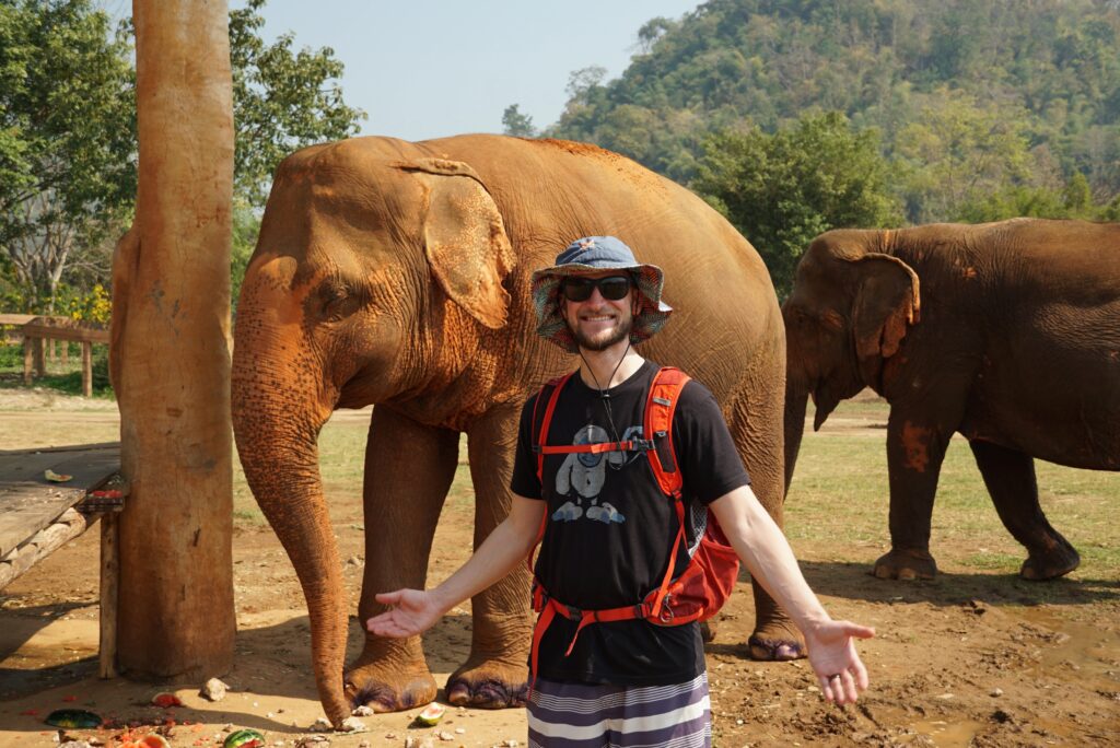 Jake posing in front of an elephant