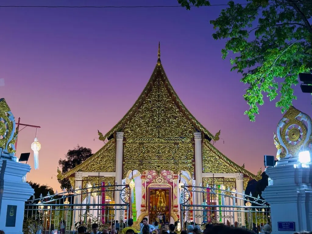 A temple in Chiang Mai glowing under a purple sunset sky